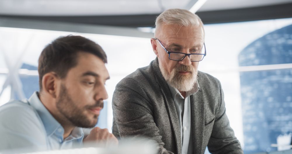 Two Man Discussing New Clients Case In Diverse Workspace of Law Firm.