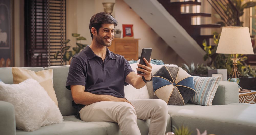 Indian Man Doing in Video Call, Chatting with Friends and Family via Smartphone at Home.