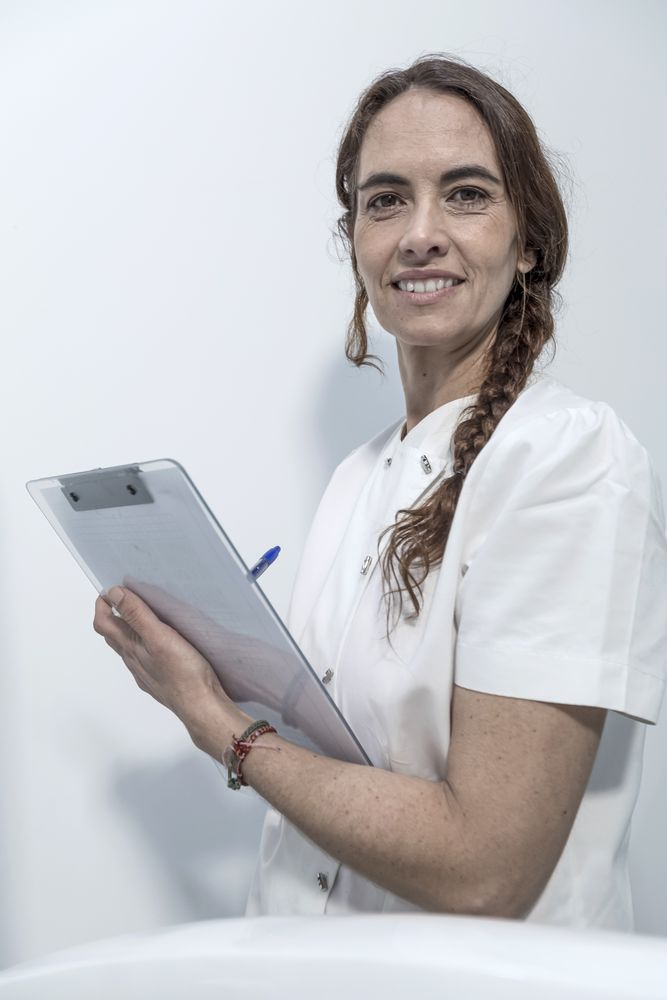 Confident experienced qualified happy smiling doctor holding clipboard with documents, vertical