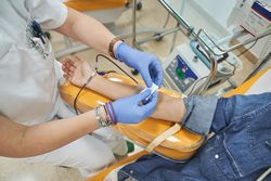 Hands of medical worker using white cotton for female patient