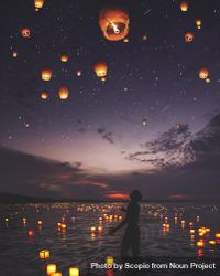 Silhouette of man standing on body of water during night time with lit lanterns in sky 0KQGZ4