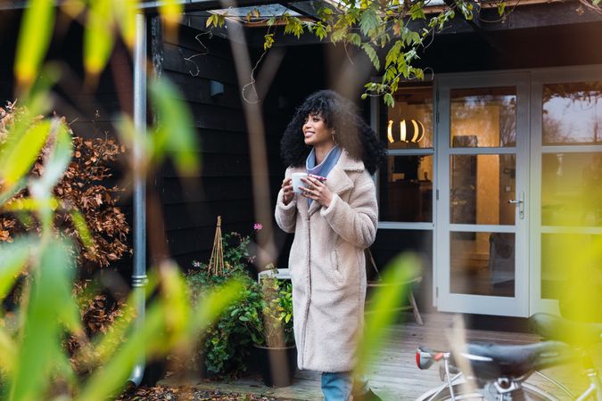 Smiling Black woman with cup of coffee