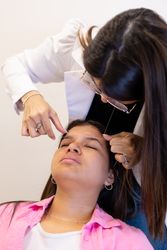 Beautician doing eyebrow threading design procedure