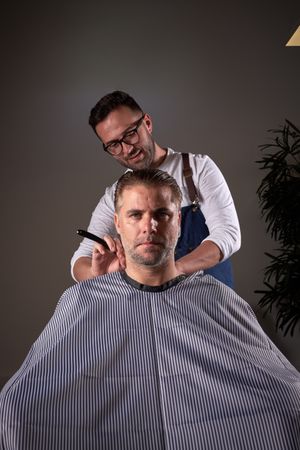 Barber shaving neck of man