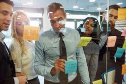 Diverse colleagues working out a problem pictured through the glass
