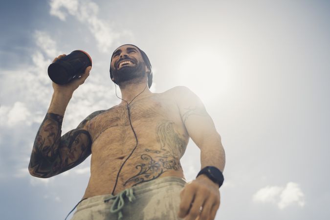 Shirtless man drinking during training