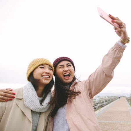 Two young female friends take selfie in winter clothes