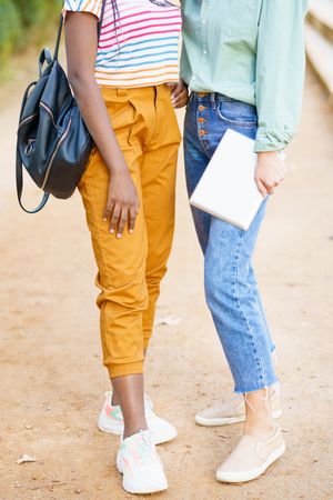 Bottom half of female friends in casual clothing in park