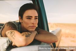 Ponderous woman resting head on crossed arms over open window of classic truck 41NMgb