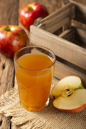 Apple juice and red apples on the table.
