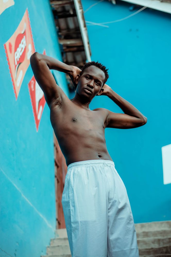 Topless man holding back of his head with both hands