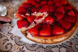 woman hand cutting strawberry cake with knife