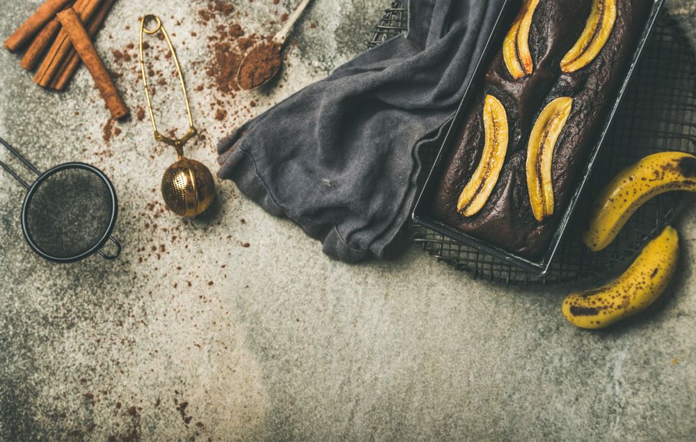 Freshly baked dark chocolate banana bread cake on concrete counter, with copy space