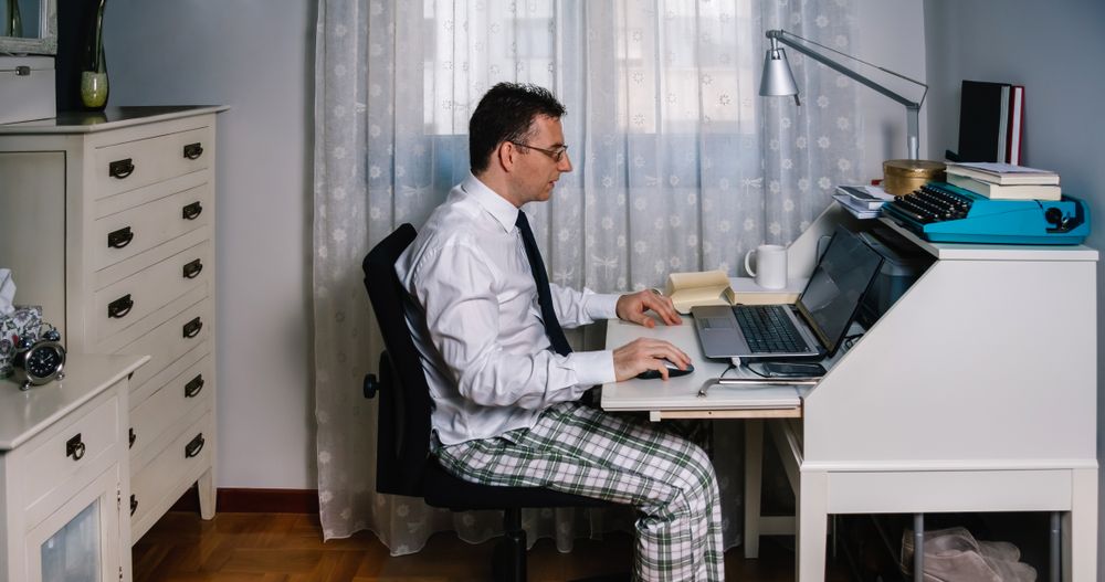 Man teleworking wearing shirt, tie and pajama pants