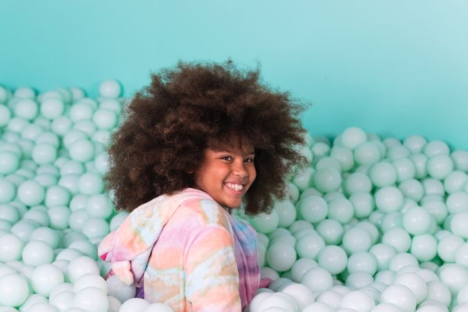 Cheerful child in ball pit