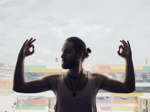 Male making yoga exercise near window
