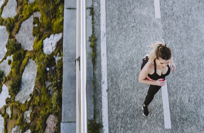 Woman running on embankment near water