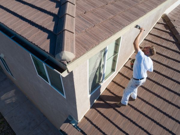 Professional Painter Using A Brush to Paint House Fascia
