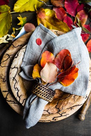 Autumnal place setting with yellow and red leaves on rustic background with copy space