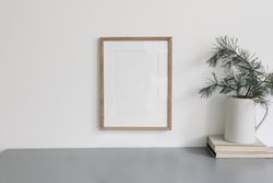 Wooden frame hung above desk with branches and books