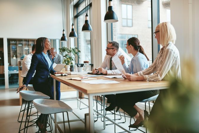 Group of people collaborating at a long table in a modern bright office