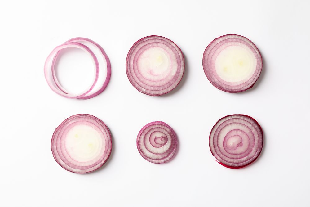 Flat lay composition with red onion rings on blank background