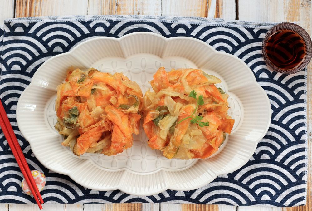 Top view of plate of kakiage vegetable tempura served with dipping sauce