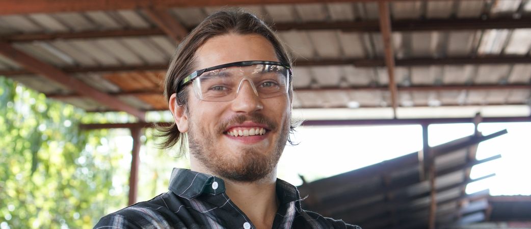 Portrait of smiling male carpenter looking at camera in his workshop