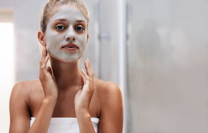 Close up shot of woman with facial mask in bathroom