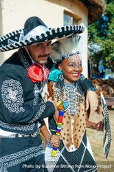Groom in traditional Mexican outfit embracing bride in traditional Zulu attire 5ngBQ4
