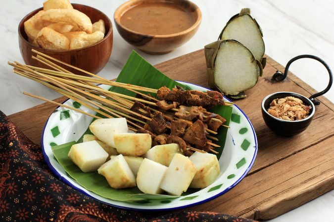 Plate of beef sate skewers served with spicy peanut sauce and sides