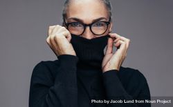 Mature female covering face with dark turtleneck 4MDD15
