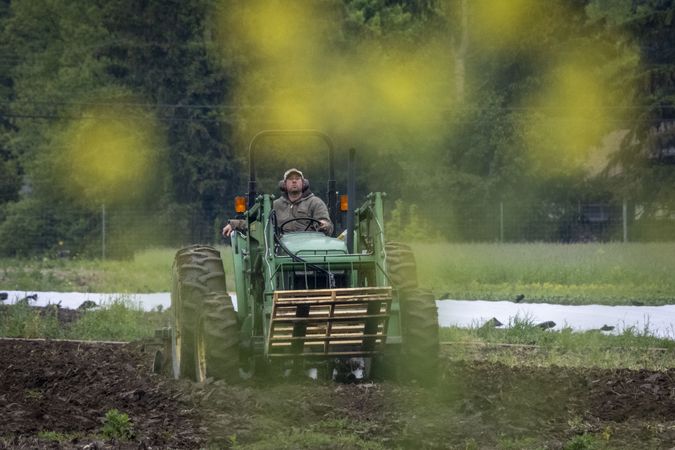 Copake, New York - May 19, 2022: Man on tractor in muddy field