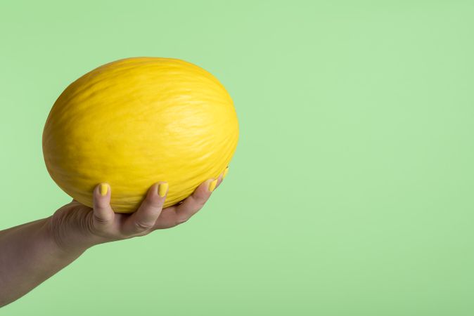Honeydew melon held in hand