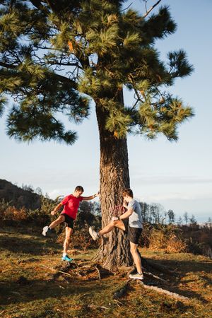 Active men warming up before running in mountains
