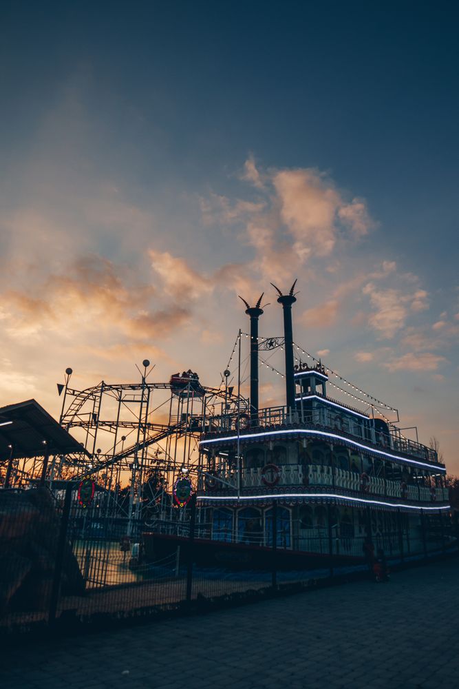 Tourist ship and roller coaster in entertainment park