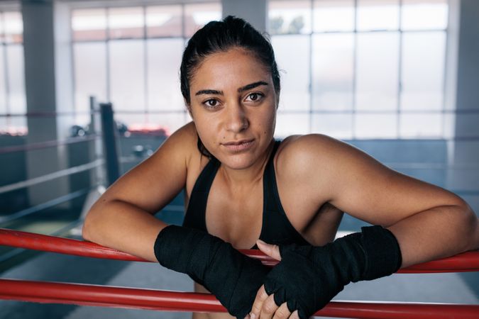 Proud female boxer inside a boxing ring with hands wrapped