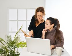 two women working in the office looking up customer data in the
