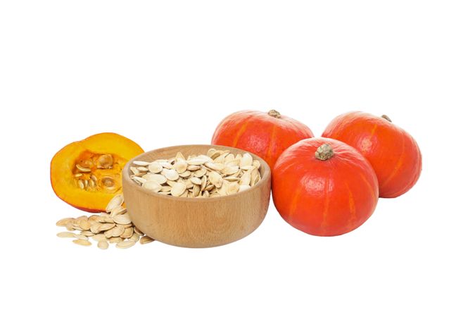 Fall season food - pumpkin seeds, isolated on light background