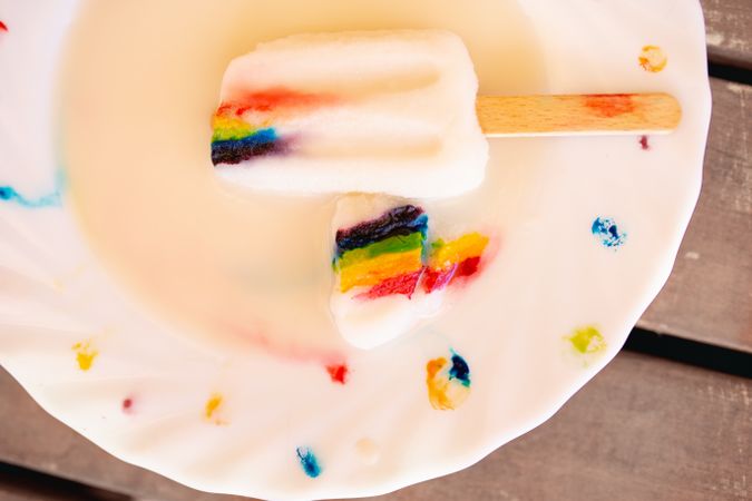 Ice cream on wooden stick with LGBTQIA symbol on decorated plate