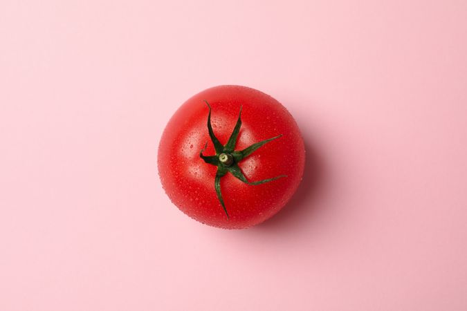 Fresh ripe tomato on pink background, top view