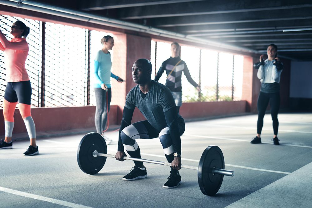 Multi-ethnic group of people doing various work out in covered carpark
