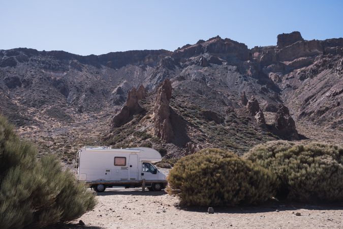 Camper on road against rocky mountains