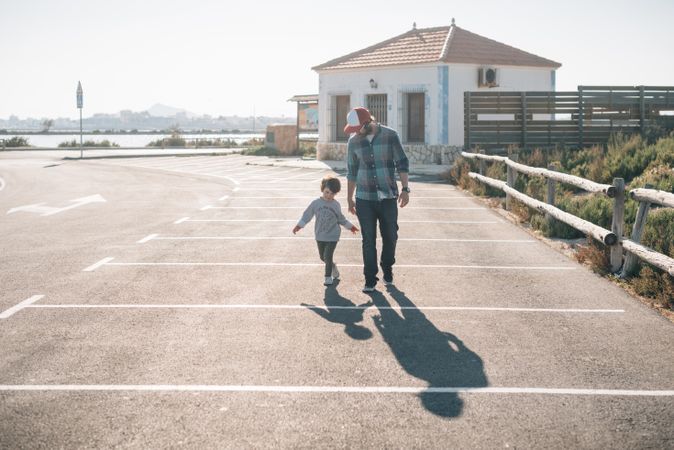 Man with boy walking on street