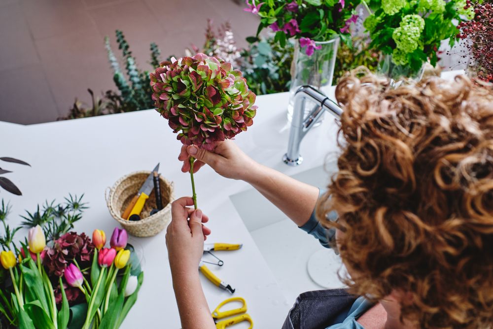 Unrecognizable woman with bunch of flowers in floral shop