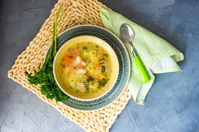 Top view of hearty chicken soup on placemat