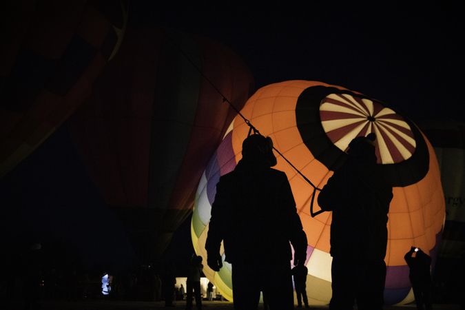 Hudson, WI, USA - February 8th, 2020: Two people inflating a hot air balloon at dusk