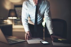 Professional man standing and going over a document with a pen