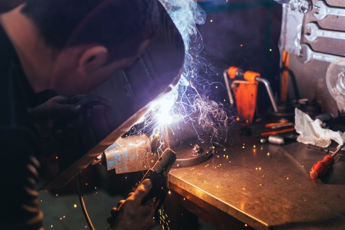 Professional welder in mask welding metal