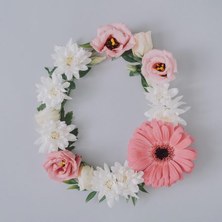 Creative flat lay composition with spring flowers in egg shape and gray background